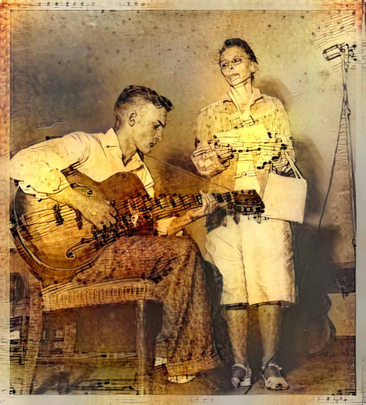 A woman watches a young man play guitar, at what is possibly the Ozark Folk Festival in the 1940s.